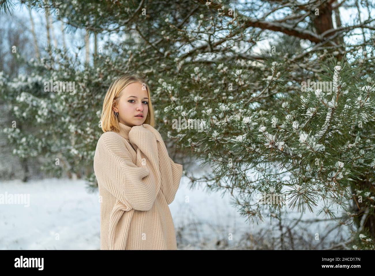 Portrait Mädchen Teenager blond Winter auf dem Hintergrund von schneebedeckten Bäumen Stockfoto