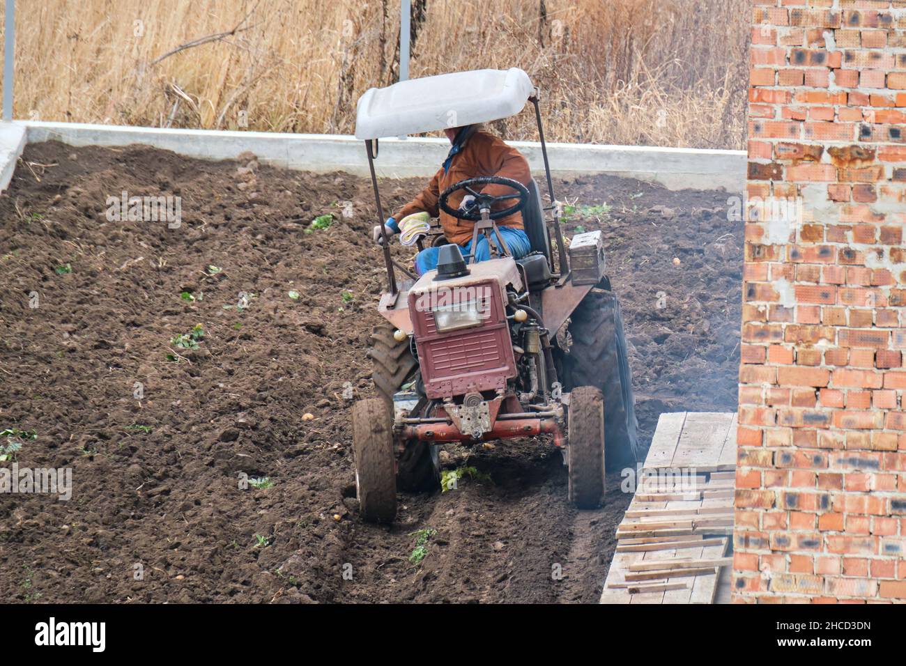 Kleiner Bauernhof Traktor Pflügen landwirtschaftlichen Feld im Spätherbst. Stockfoto