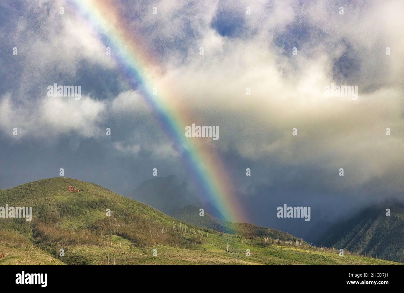 Wunderschöner Regenbogen, der sich über die westlichen maui Berge erstreckt. Stockfoto