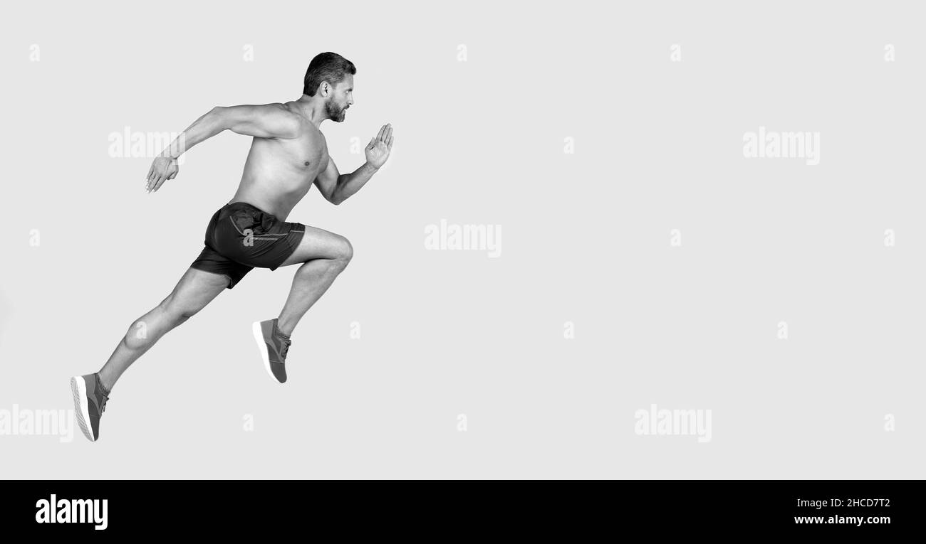 Sportler Mann Läufer laufen zum Erfolg oder springen hoch auf grauem Hintergrund, kopieren Raum, Sport Stockfoto