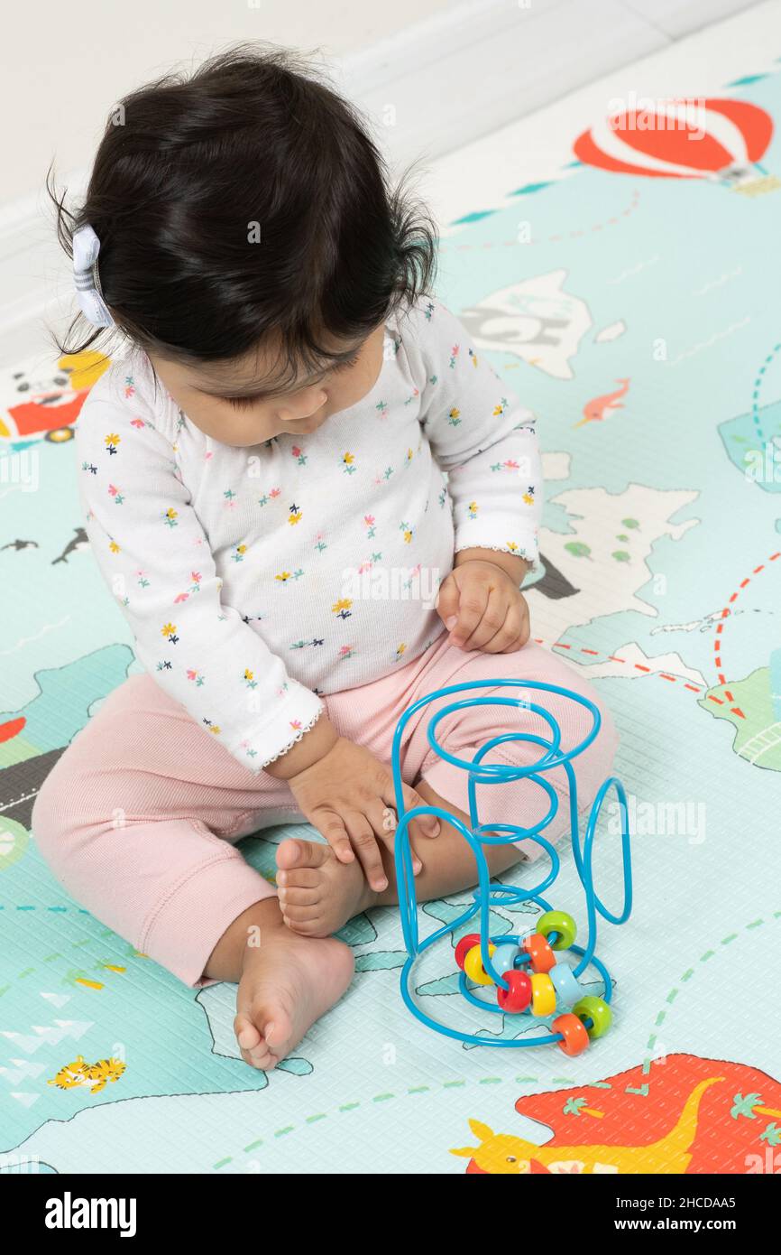 8 Monate alt Baby Mädchen Betrachtung Spielzeug Piaget Objekt  Dauerhaftigkeit Serie 1 von 1 Stockfotografie - Alamy