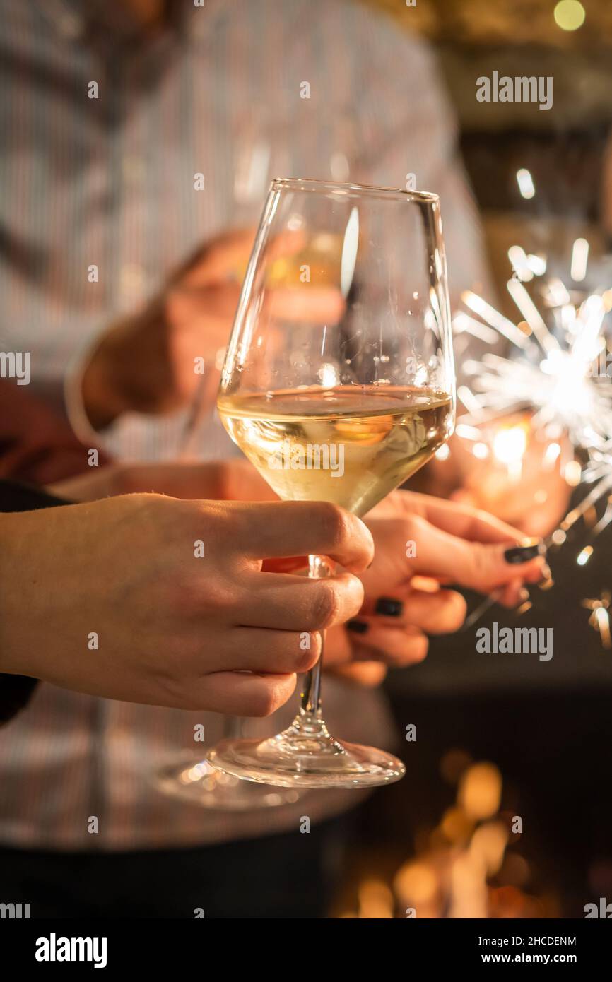 Nahaufnahme der Hände einer Gruppe von Menschen, die Gläser Wein halten und funkeln, während sie toasten und den Fokus im Innenbereich auf ein Glas Wein zum Geburtstag oder neu feiern Stockfoto