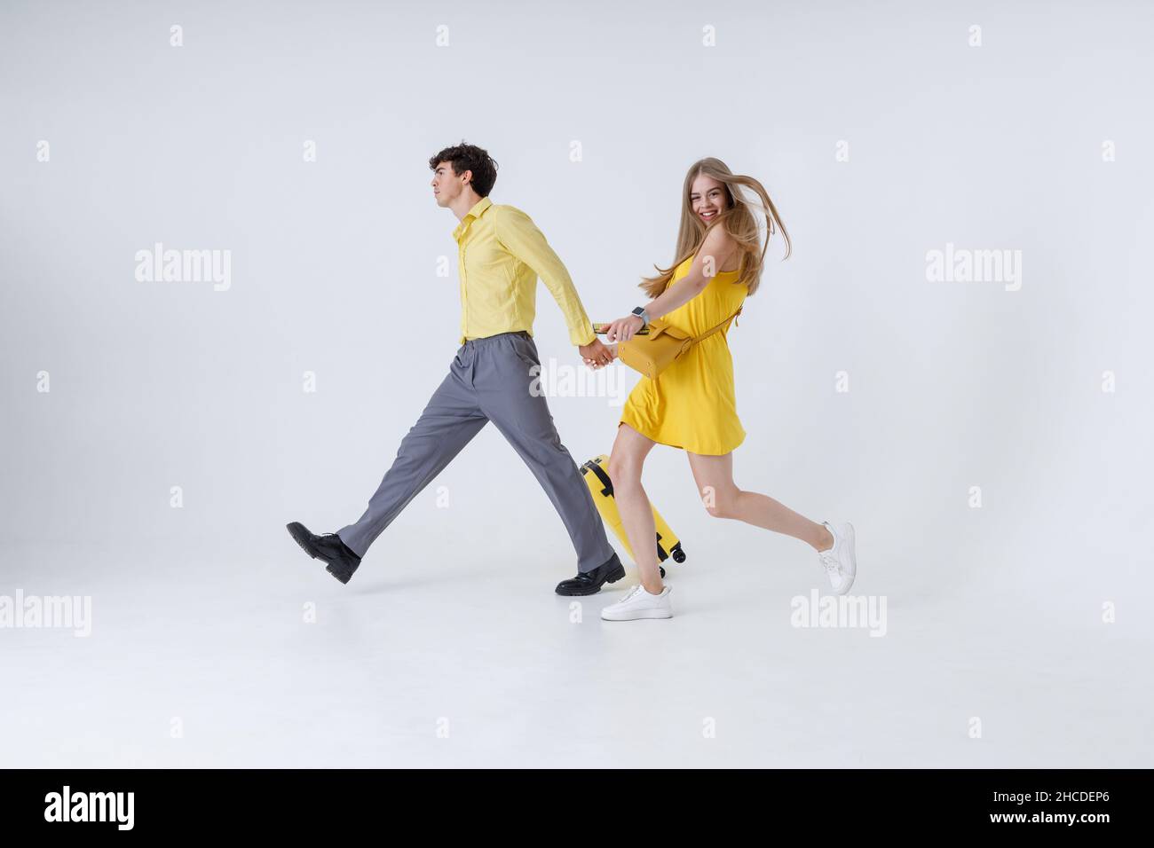 Schönes junges Paar mit Reisekoffer, der Hand in Hand geht Stockfoto