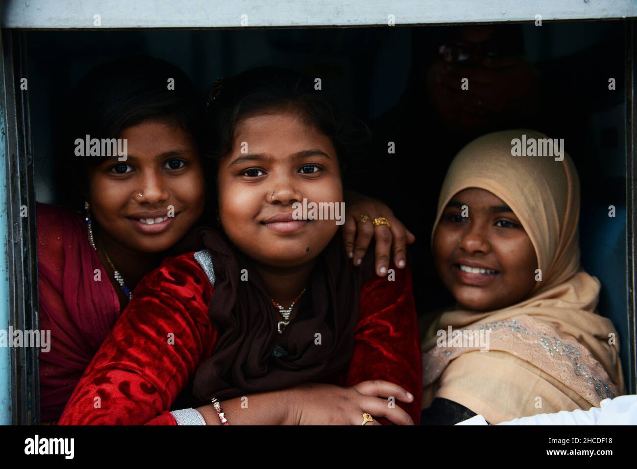 Indische Frauen, die aus ihrem Zug in Tamil Nadu, Indien, schauen. Stockfoto