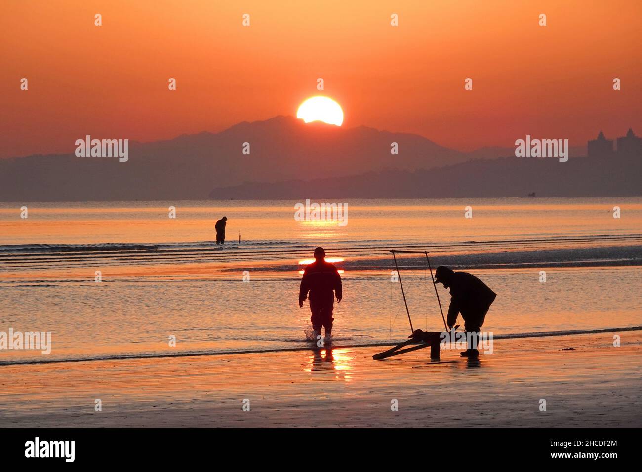 YANTAI, CHINA - 8. DEZEMBER 2021 - Sonnenaufgang über dem Meer in Yantai, Ostchinas Provinz Shandong, 8. Dezember 2021. Stockfoto
