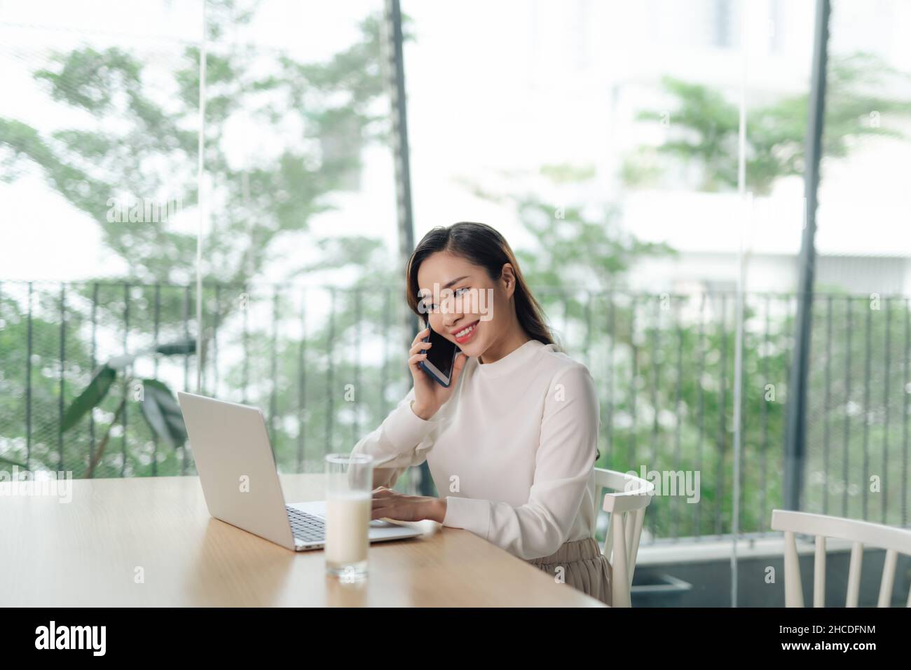 attraktive Frau am Telefon Notizen in ihrem Haus Stockfoto