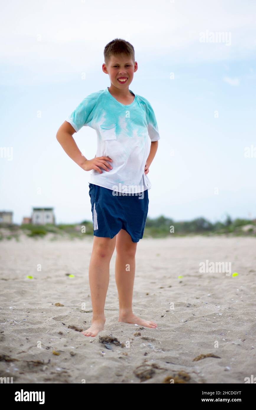 Ein barfuß-Teenager steht am Sandstrand. Sportliche Müdigkeit. Stockfoto