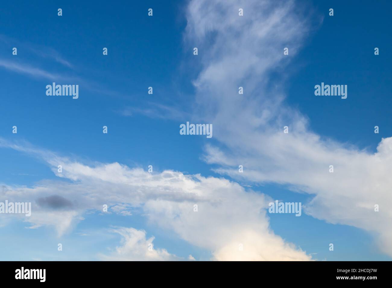 Weiße Cumulus Wolken in einem blauen Himmel mit. Natürliches Hintergrundfoto, das an einem sonnigen Tag aufgenommen wurde Stockfoto