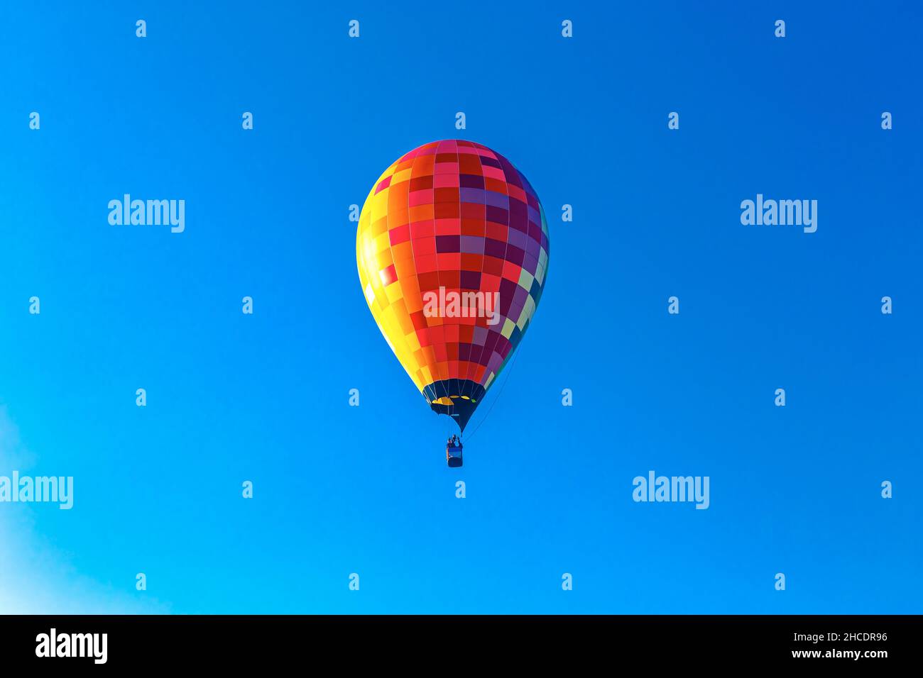 Farbenfroher Heißluftballon vor einem morgendlichen blauen Himmel im Landkreis Maramures. Foto aufgenommen am 2nd. Oktober 2021 in der Nähe eines Feldes in Rogoz, Maramures County, R Stockfoto