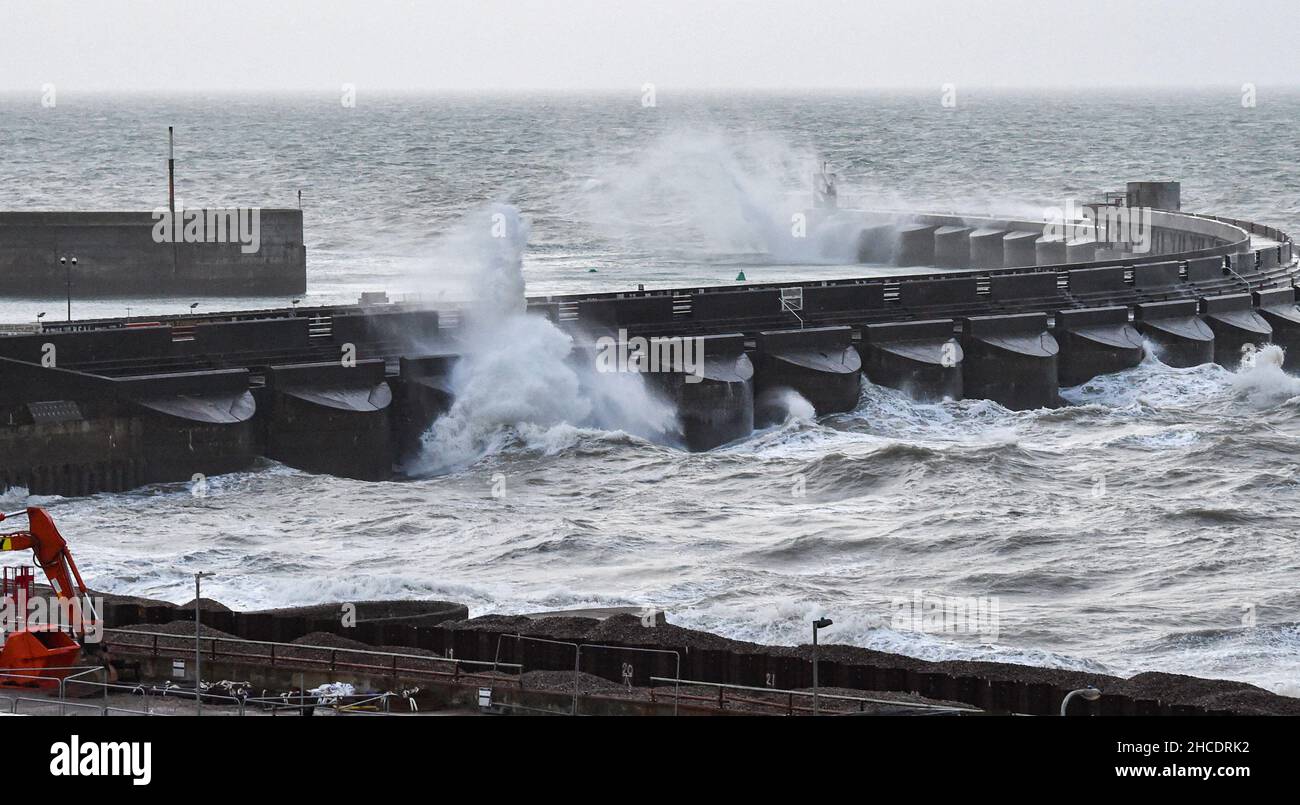 Brighton UK 28th December 2021 - Wellen schlagen über Brighton Marina, während starke Winde heute früh an der Südküste entlang fegen, mit milden, aber nassen Wetterprognosen für das neue Jahr in Großbritannien : Credit Simon Dack / Alamy Live News Stockfoto