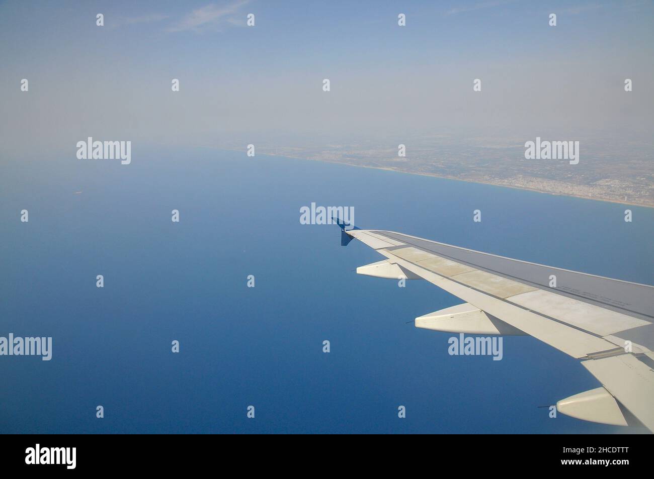 Erhöhte Aussicht auf das Mittelmeer und die Wolken, durch das Fenster eines Airbus A320-200 Flugzeug gesehen Stockfoto