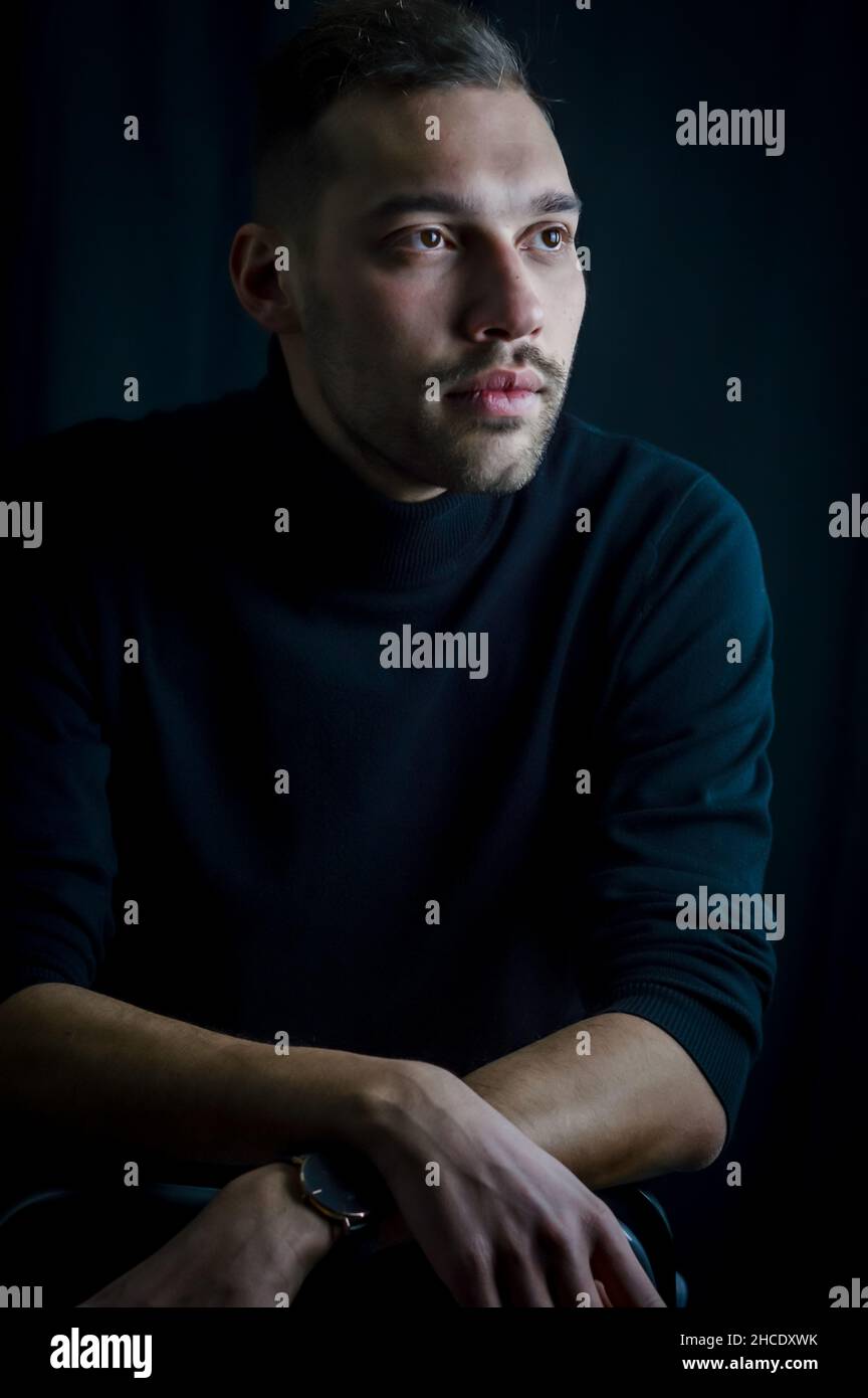 Porträt eines jungen Mannes, der mit seinem Blick an anderer Stelle in seinen Gedanken verloren scheint Stockfoto