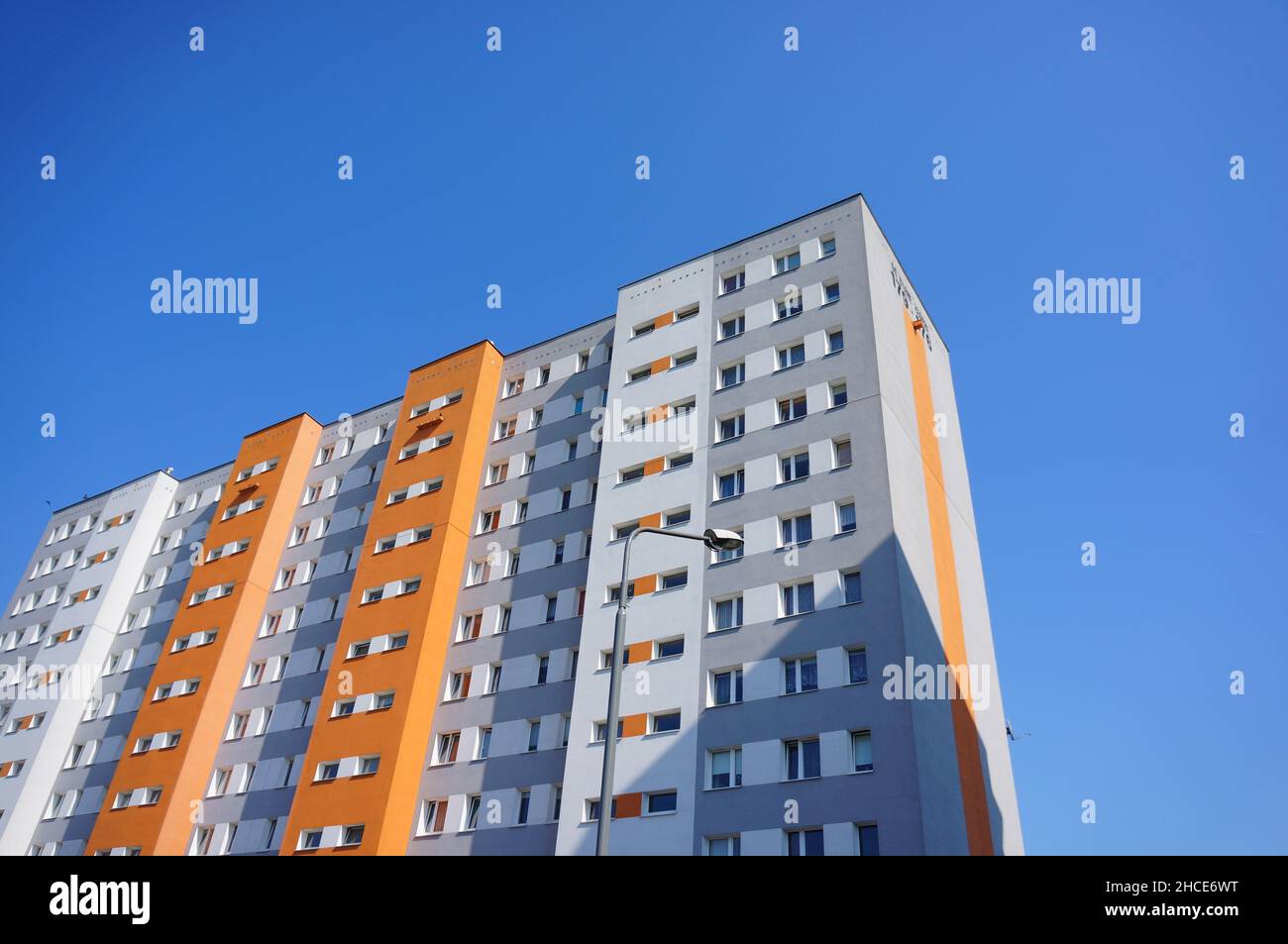 Graues und orangefarbenes Apartmentgebäude im Stadtteil Stare Zegrze. Stockfoto