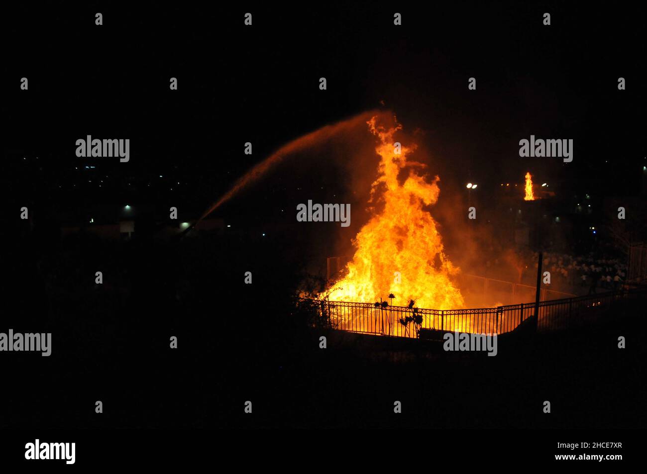 Feuerwehrmann ein großes Lagerfeuer, während die Lag B'Omer feiern (Lag B'Omer ist ein Tag für Lagerfeuer feiern löschen.) Stockfoto