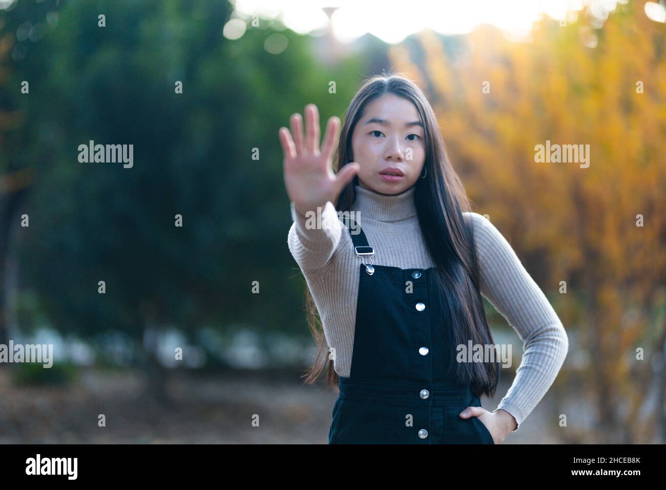 Junge asiatische Teenager-Mädchen zeigt Stop-Geste mit ihren Händen. Stockfoto