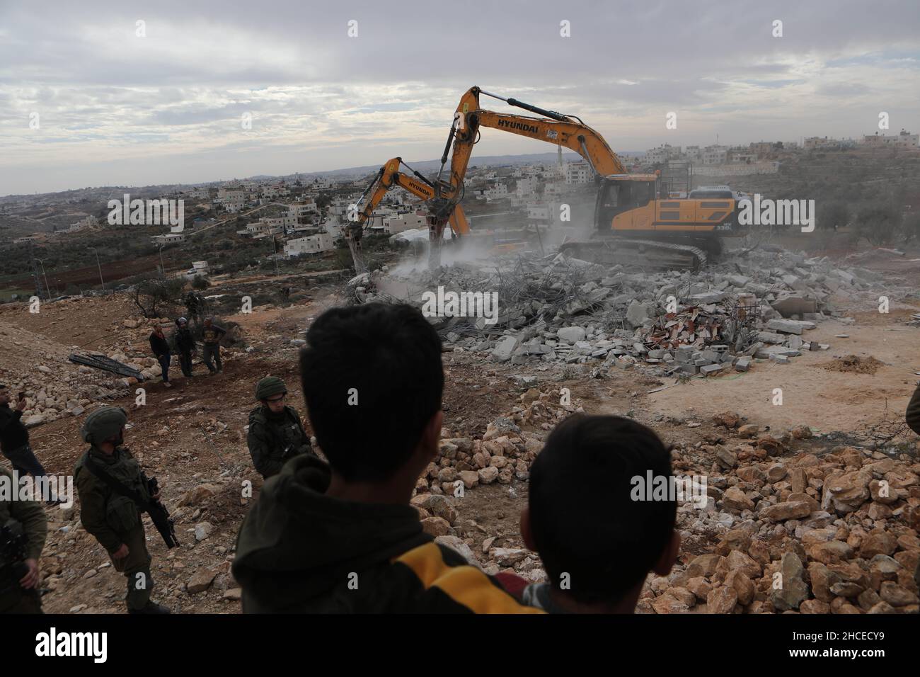 Hebron, Westjordanland-Stadt Hebron. 28th Dez 2021. Bulldozer zerstören ein palästinensisches Haus, das die Israelis behaupten, ohne Genehmigung gebaut zu werden, im Süden der Stadt Hebron im Westjordanland, am 28. Dezember 2021. Kredit: Mamoun Wazwaz/Xinhua/Alamy Live Nachrichten Stockfoto