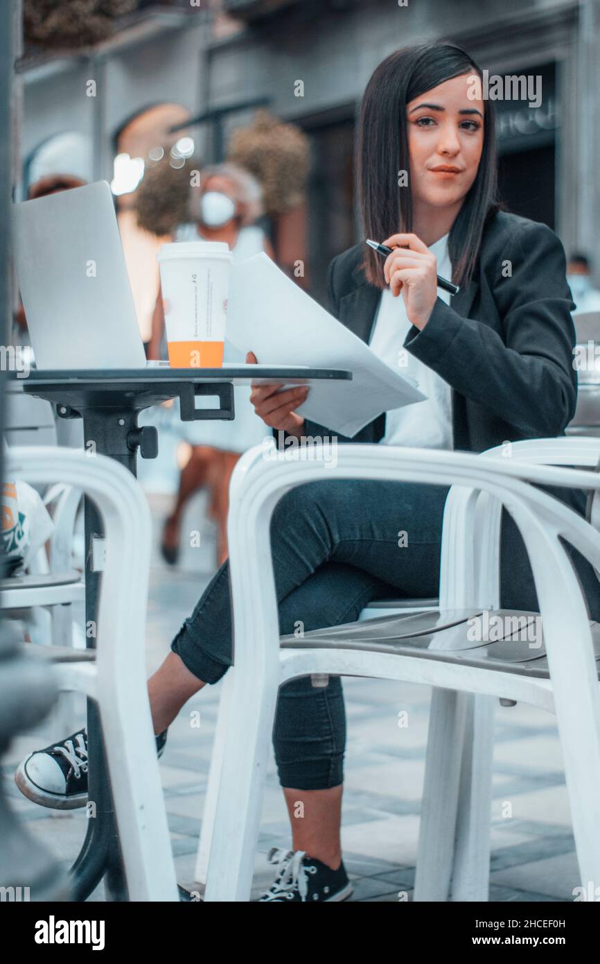 Eine Arbeitslehrerin am Morgen, die die College- und High-School-Prüfungen ihrer Schüler überprüft und korrigiert Stockfoto