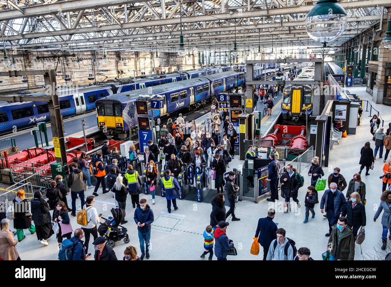 Pendler, die mit Zügen und in belebten Bahnhöfen unterwegs sind Stockfoto