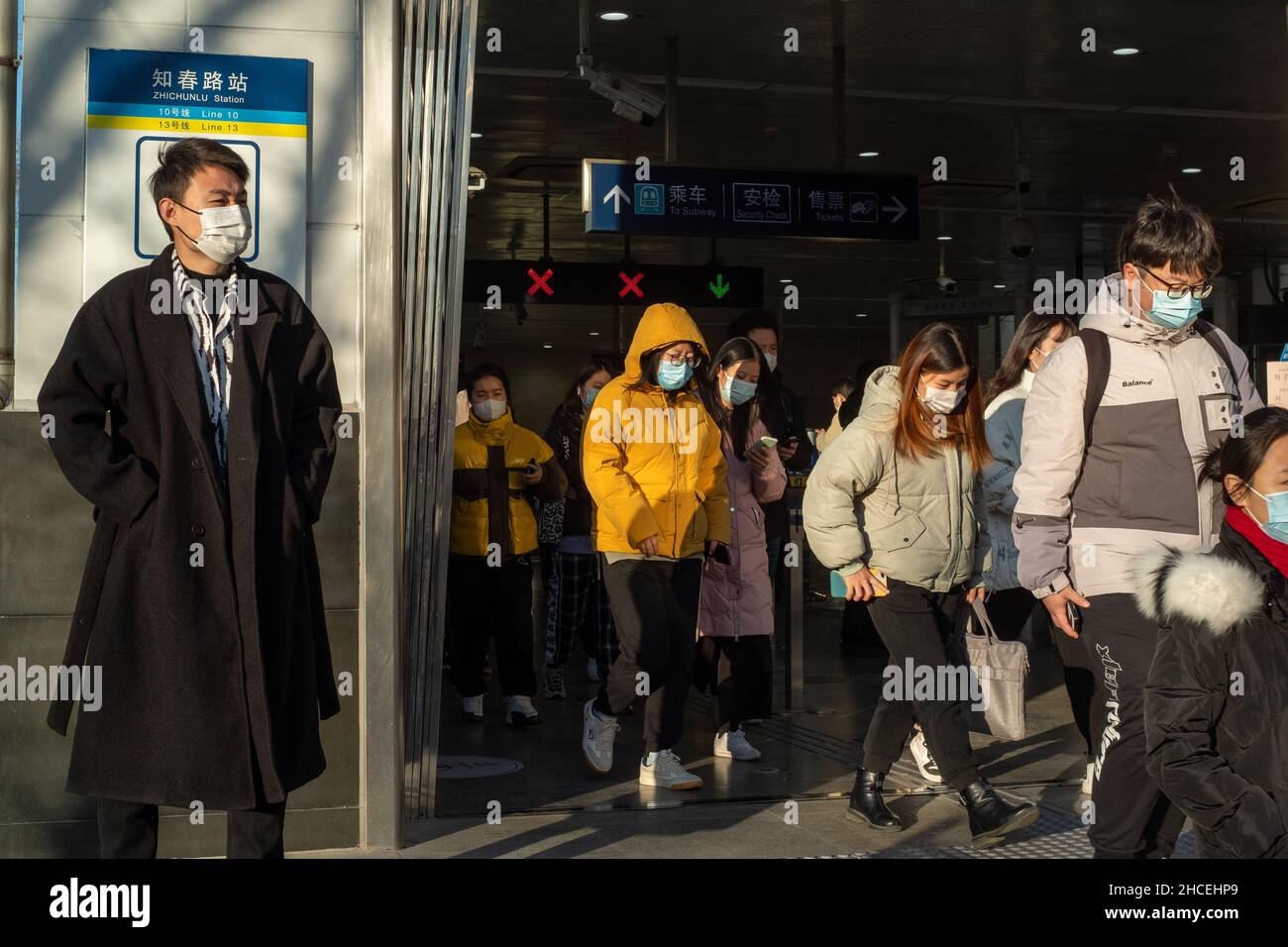 Pendler am Morgen gehen aus einem U-Bahn-Ausgang in Zhongguancun, dem Technologiezentrum in Peking, China. 27-Dez-2021 Stockfoto