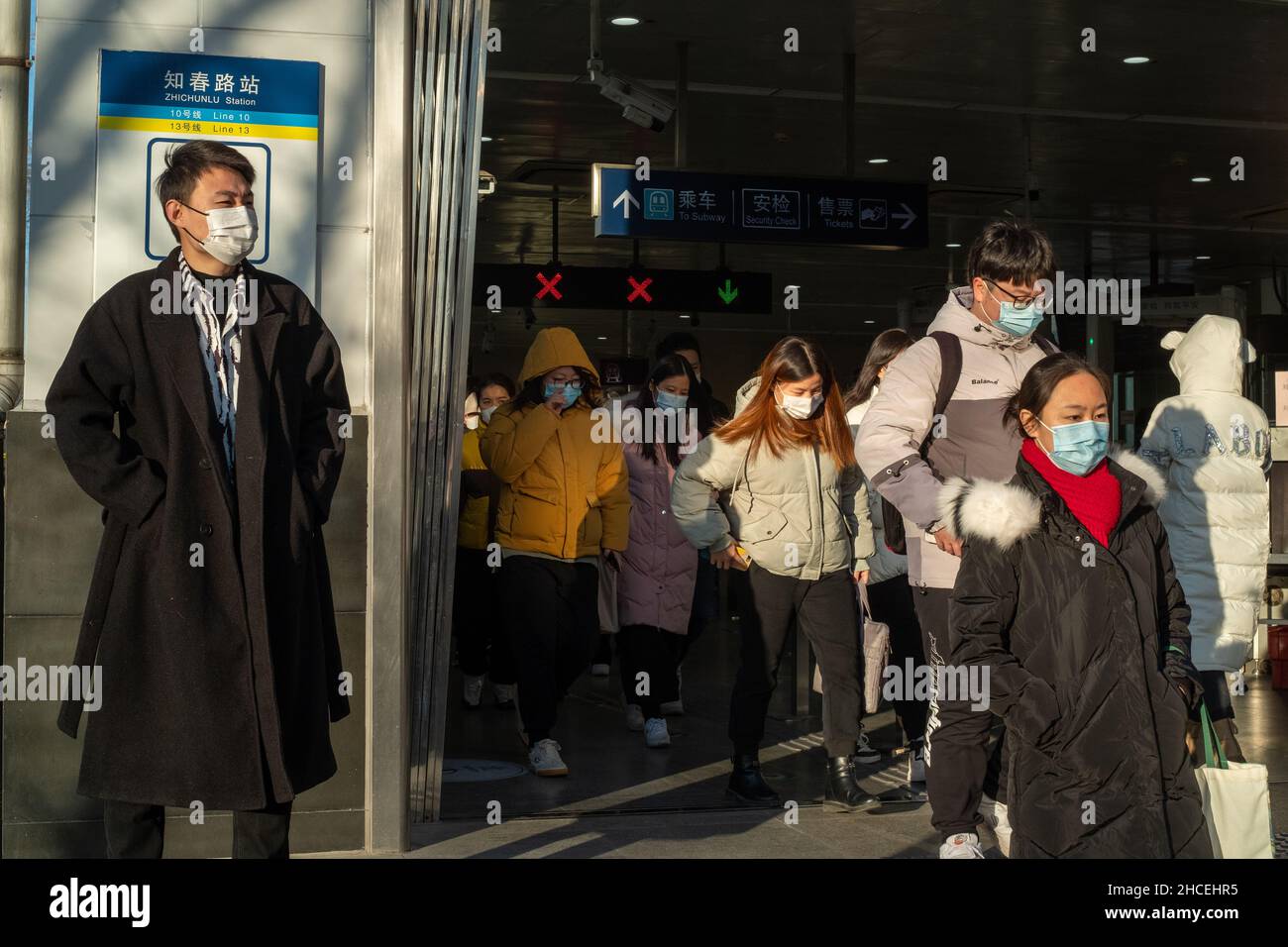 Pendler am Morgen gehen aus einem U-Bahn-Ausgang in Zhongguancun, dem Technologiezentrum in Peking, China. 27-Dez-2021 Stockfoto