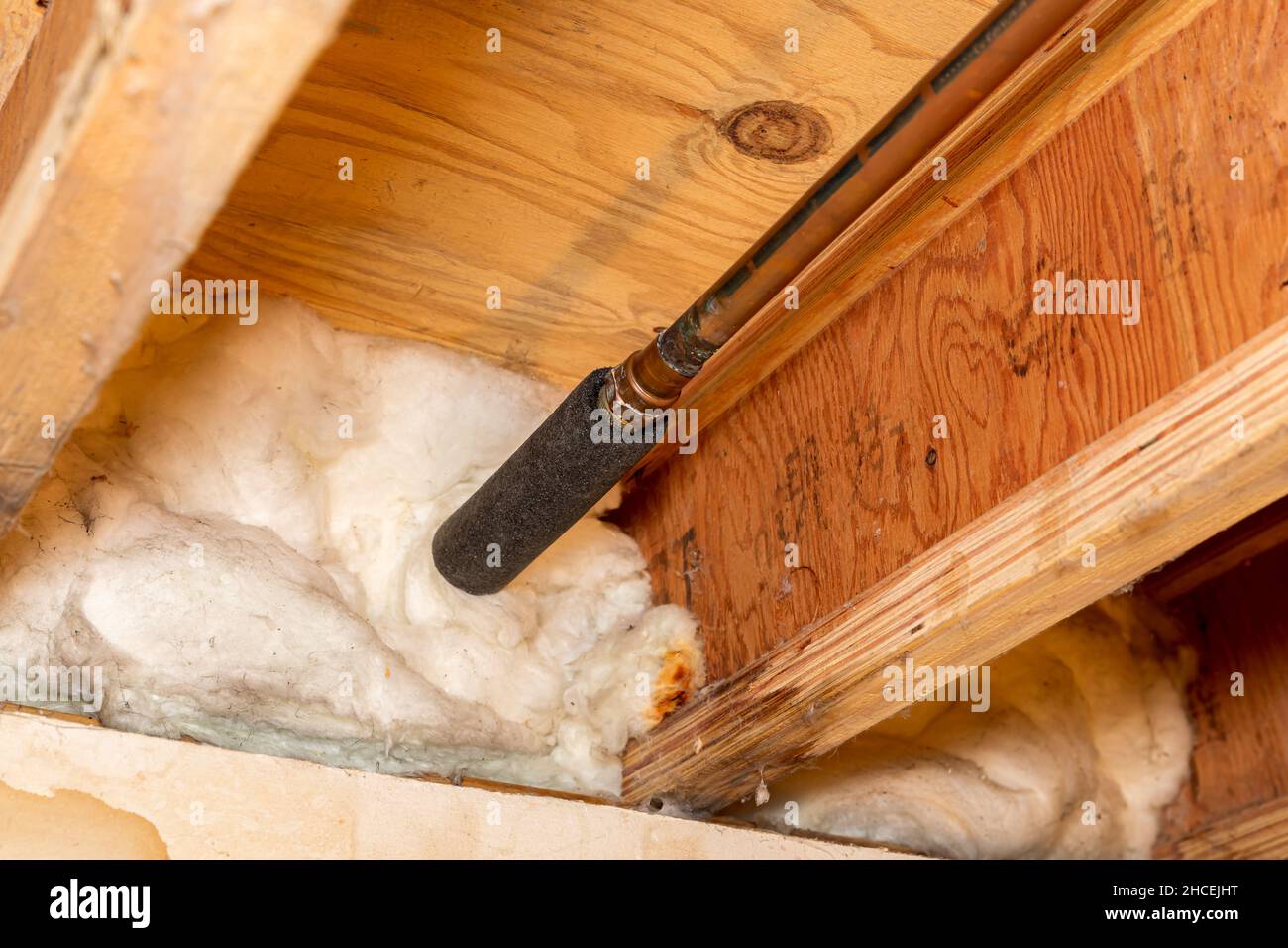 Wasserleitung mit Isolierung im Kriechraum des Hauses. Sanitär Frostschutz, Energieeinsparungen und Hausreparatur Stockfoto