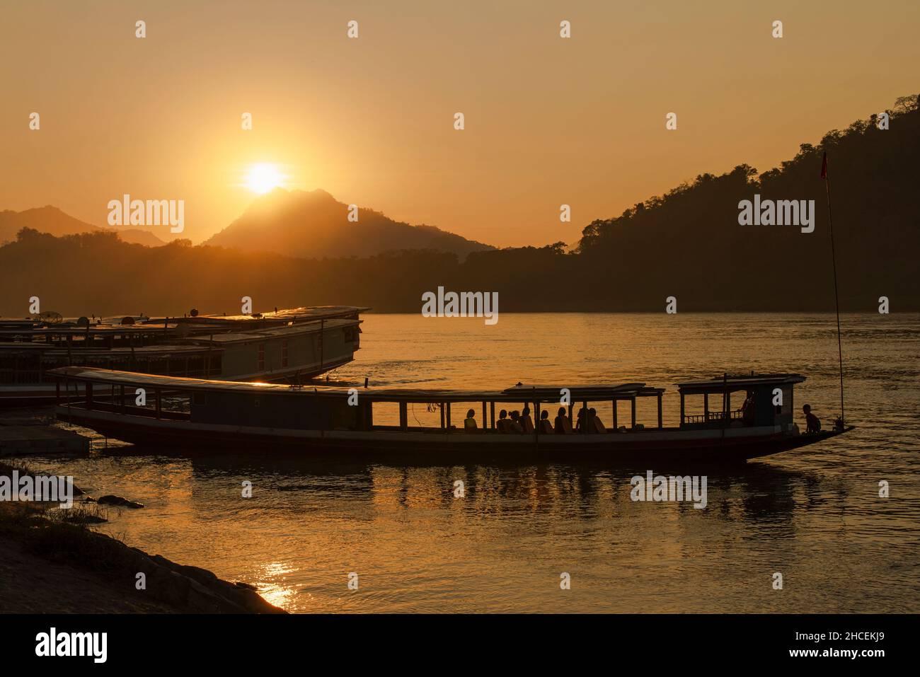 Silhouette eines langen Bootes bei Sonnenuntergang in Luang Prabang Stockfoto