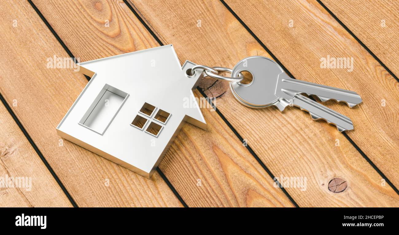 Kauf eines Hauses mit zwei Hausschlüsseln auf einem Holzhintergrund Stockfoto