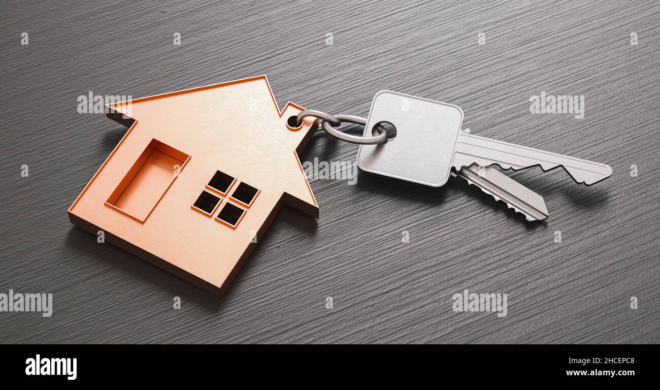 Kauf eines Hauses mit zwei Hausschlüsseln auf einem dunklen Holzhintergrund Stockfoto