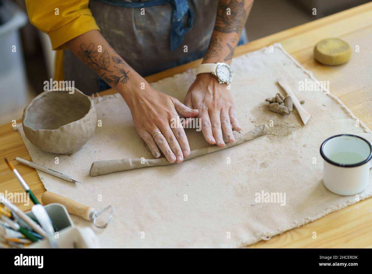 Künstlerarbeit mit rohem Ton. Hände von weiblichen Handwerk Keramiker Schimmel nassen Topf auf dem Tisch in Werkstatt-Studio Stockfoto