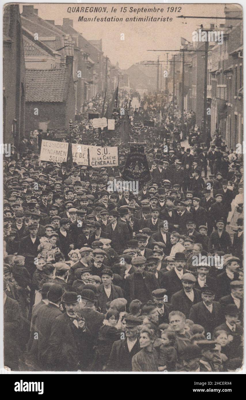 'Quaregnon, den 15. September 1912. Manifestation antimilitariste': Postkarte mit einer Antikriegsdemonstration im belgischen Stadtbezirk Quaregnon. Einige der Demonstranten tragen Banner der Arbeiterbewegung/Gewerkschaften und Schilder, darunter eine mit einem Generalstreik Stockfoto