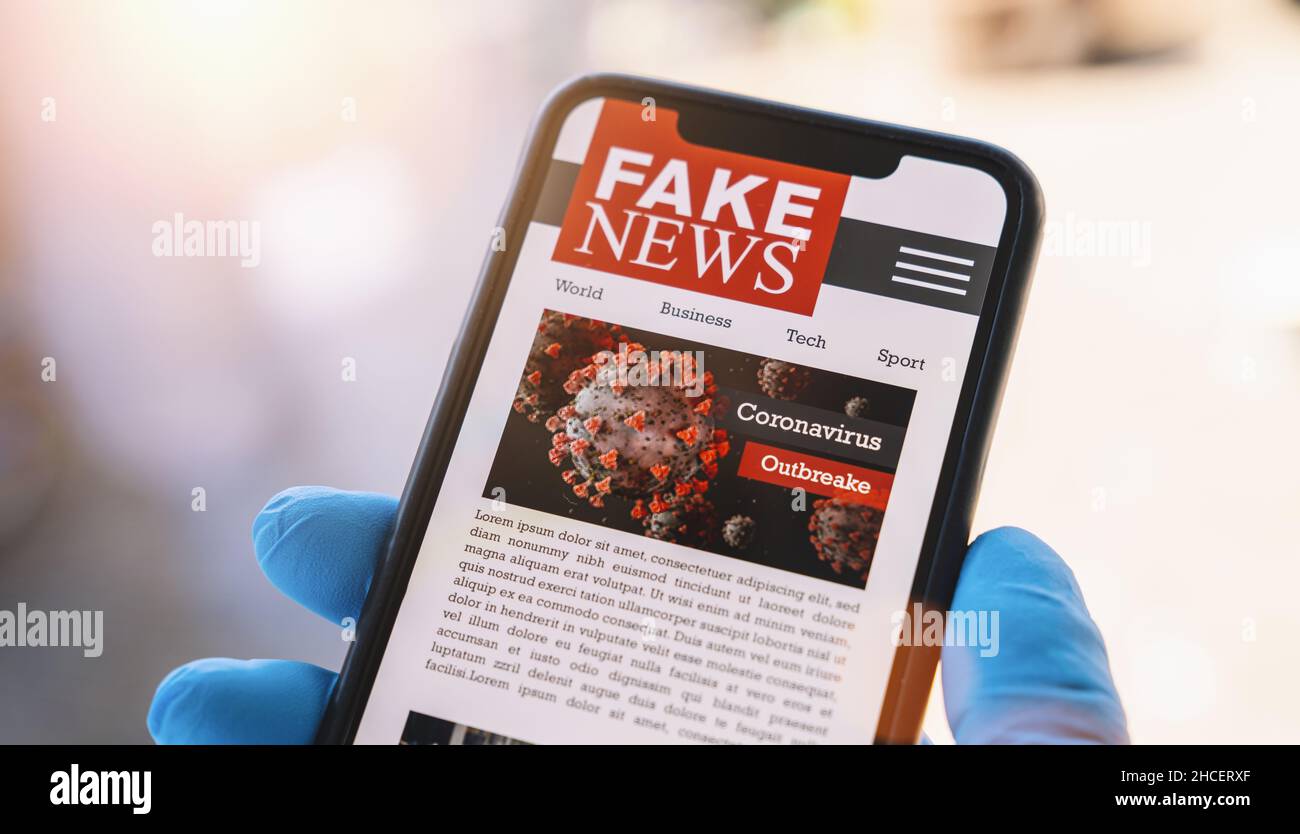 Online Corona Fake News auf einem Handy. Nahaufnahme, Mann beim Lesen gefälschter Nachrichten oder Artikel über covid-19 in einer Smartphone-Bildschirm-Anwendung. Stockfoto