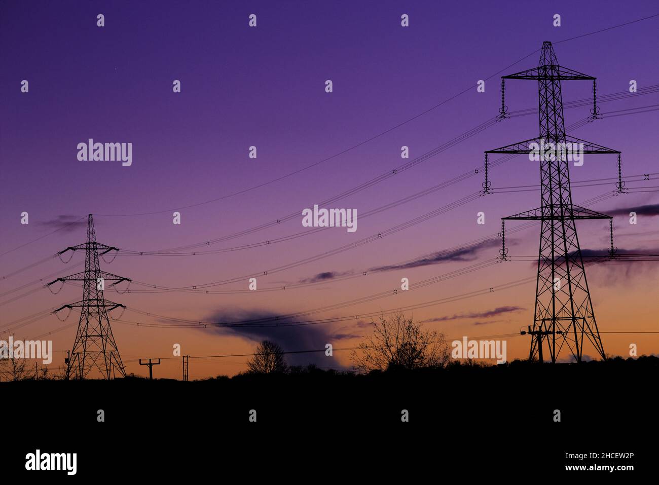 Blaue Stunden-Aufnahme von Pylonen, die gegen den frühen Nachthimmel in der Nähe von Eckington, North East Derbyshire, gedreht wurden Stockfoto