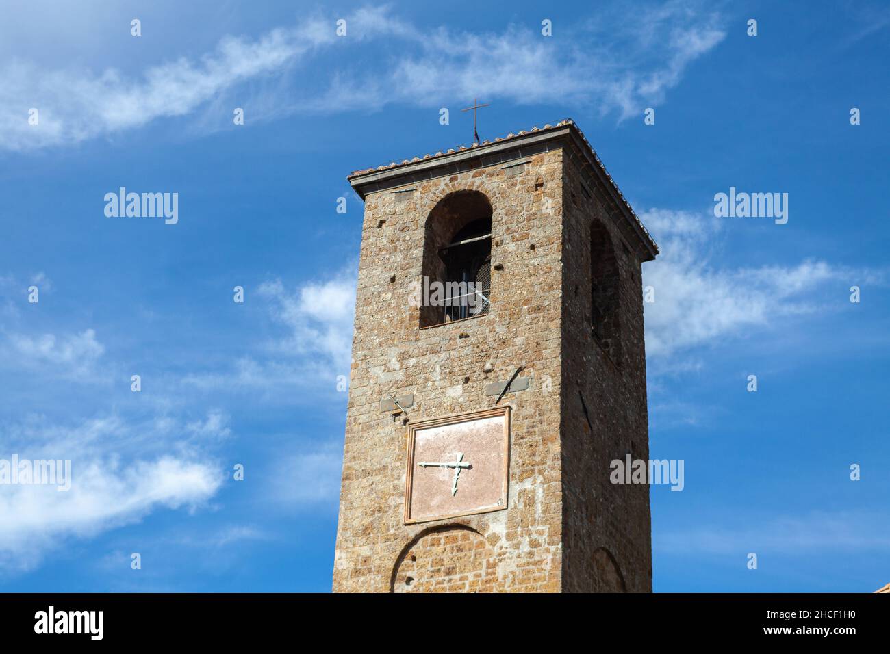 Der Glockenturm der Hauptkirche in Civita di Bagnoregio, der sterbenden Stadt, Latium, Italien, gegen blauen Himmel Stockfoto