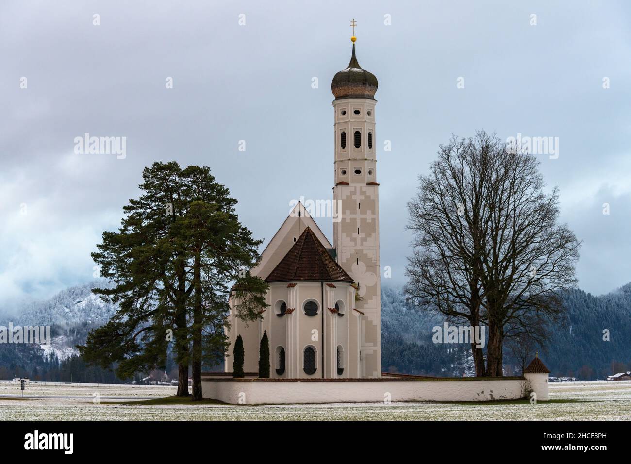 kirche st. coloman in Winterlandschaft mit Bergen im Hintergrund Stockfoto