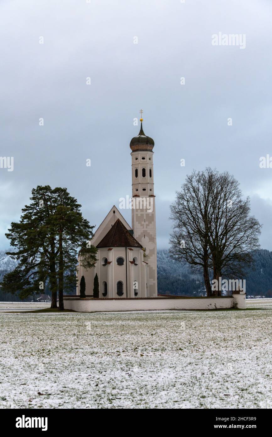 kirche st. coloman in Winterlandschaft mit Bergen im Hintergrund Stockfoto