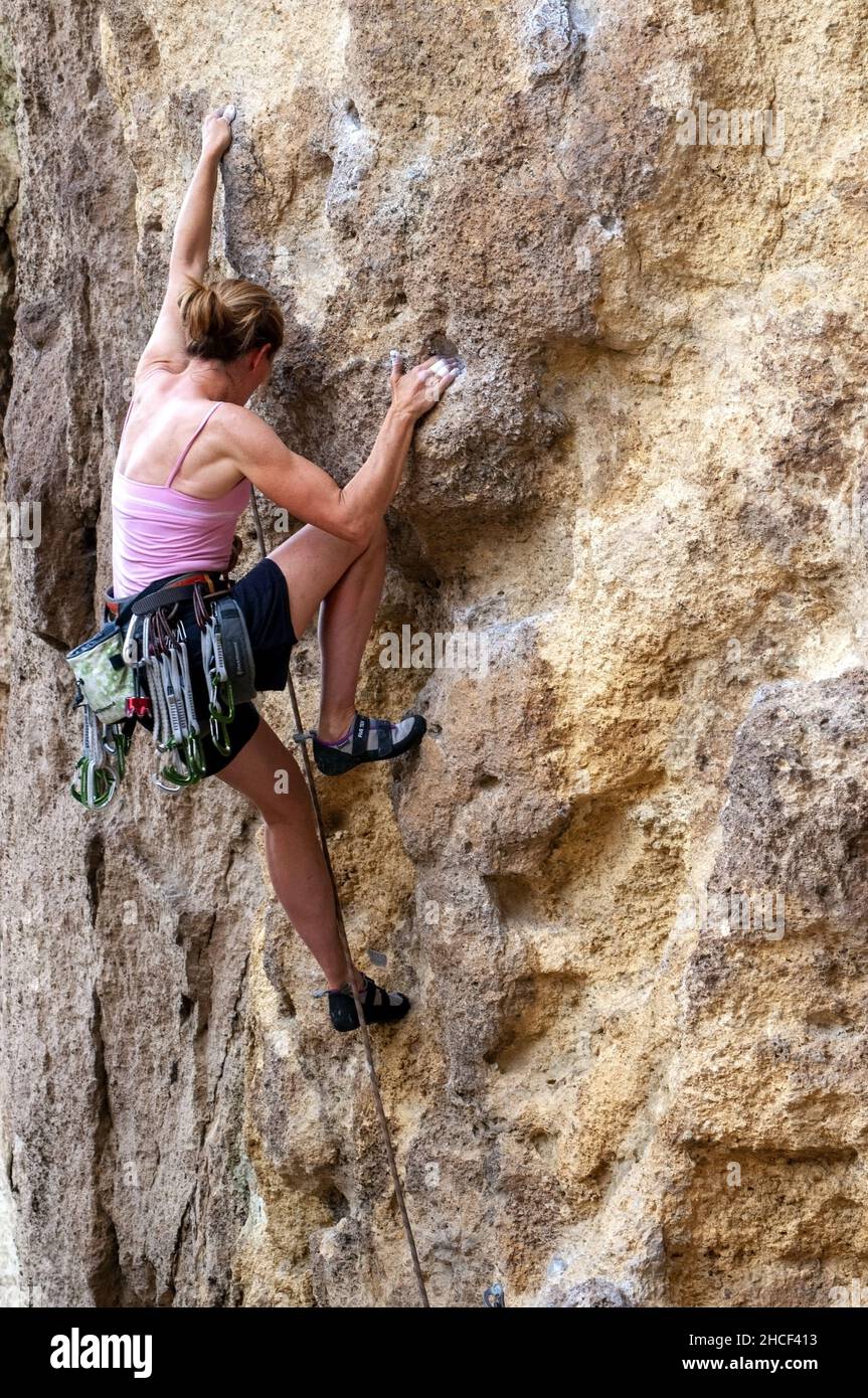 Alleinstehende weibliche Kletterei im Smith Rock State Park, Oregon Stockfoto