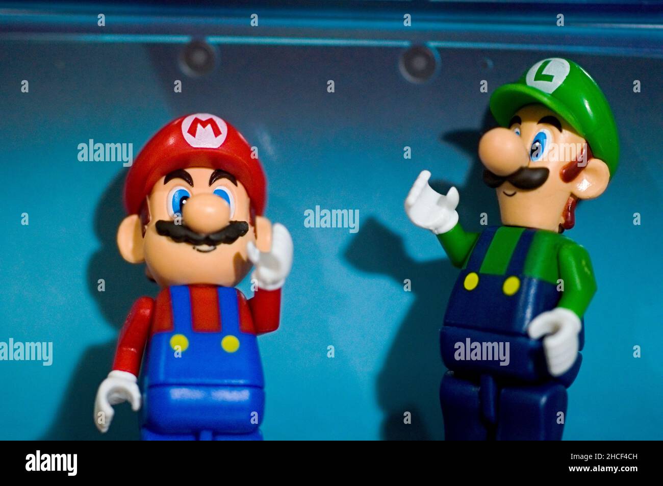 Block Mario und Luigi Spielzeug, posiert hinter einer 3DS-Box Stockfoto