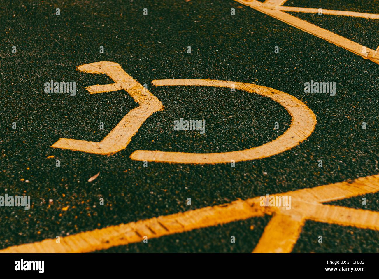 Behindertenparkplätze. Barrierefreier Parkplatz. Blaues Abzeichen. Gelbes Rollstuhlschild auf dem Boden Stockfoto