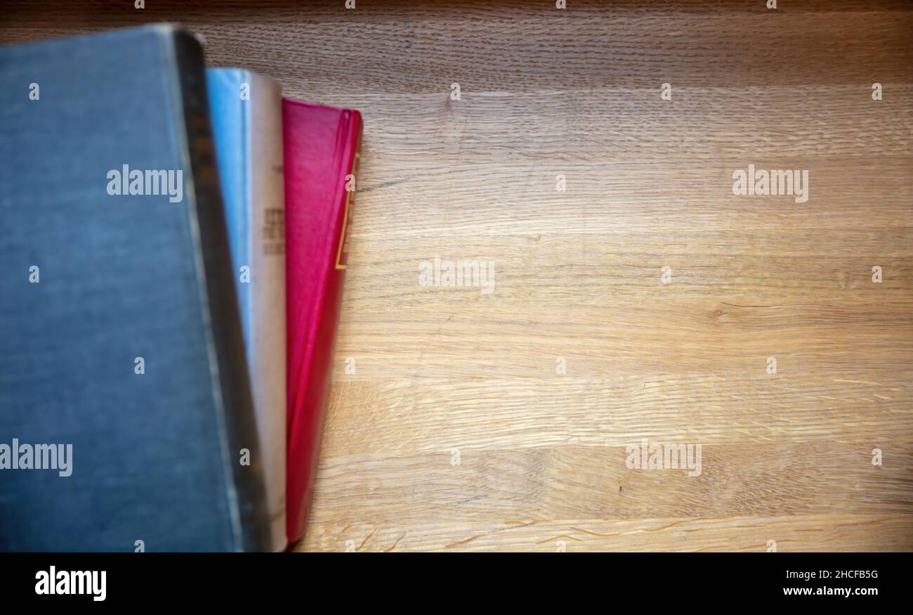 Bücher stapeln sich auf einem Tisch. Geschlossene alte Notizbücher auf Holzschreibtischhintergrund, Draufsicht. Platz kopieren, Vorlage Stockfoto
