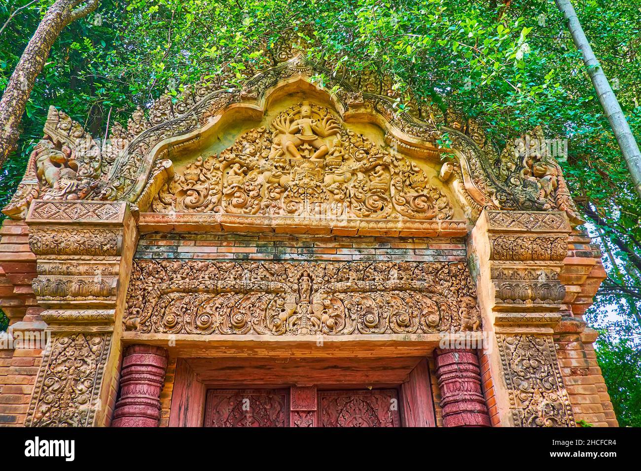 CHIANG MAI, THAILAND - 4. MAI 2019: Detail des kunstvollen Terrakotta-Tores des Baan Phor Liang Meun Terracotta Arts Hotels mit Skulpturen und feinen Blumen Stockfoto