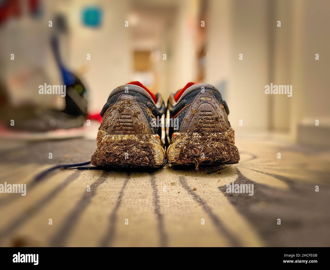 Schmutzige Laufschuhe kommen nach Hause Stockfoto