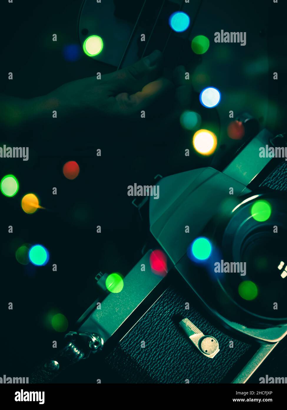 Composite-Bild von analoger Filmkamera, Bass-Gitarrenspiel und Bokeh von mehrfarbigen Lichtern Stockfoto