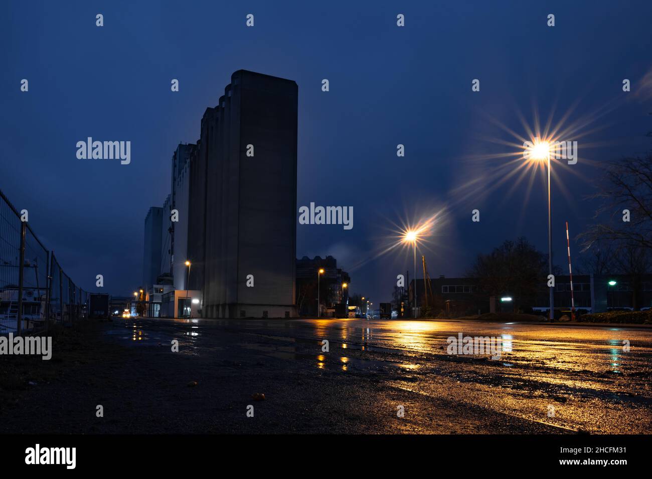 Nachtszene am Rhein-Ruhr-Hafen in Mülheim an der Ruhr, Spelddorf, Deutschland. Blick auf ein Silo vor blauem Nachthimmel. Das Wetter ist regnerisch. Stockfoto