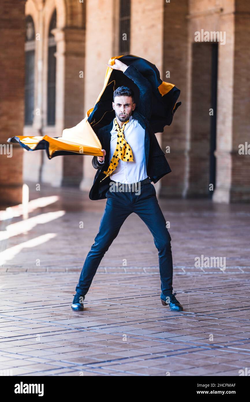 Mann mit Anzug und Stierkämpfer-Umhang tanzt Flamenco im Freien Stockfoto