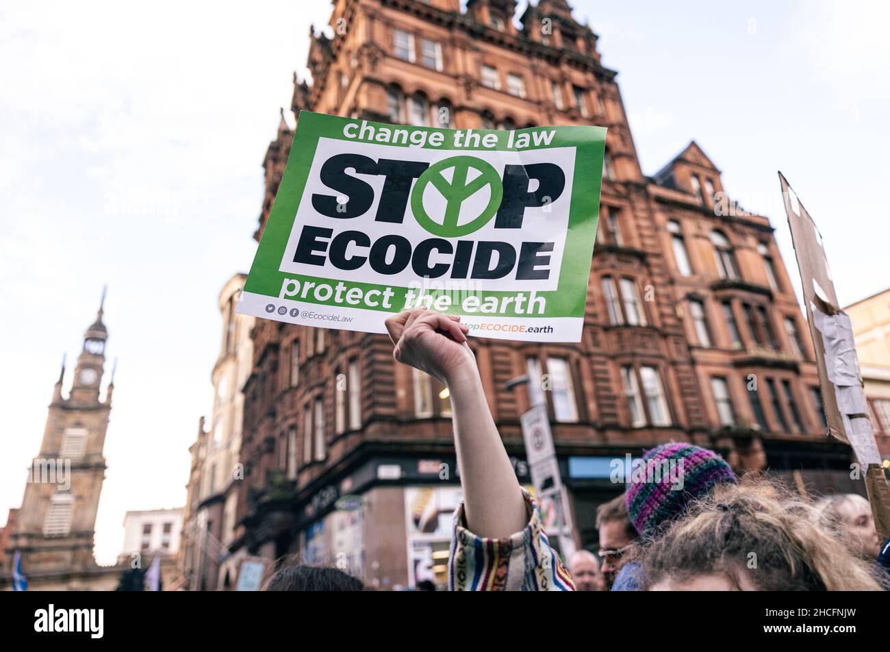 Selektive Fokusaufnahme eines Protesters mit einem Schild mit der Aufschrift „Stop Ecocide“ in Glasgow, Schottland Stockfoto