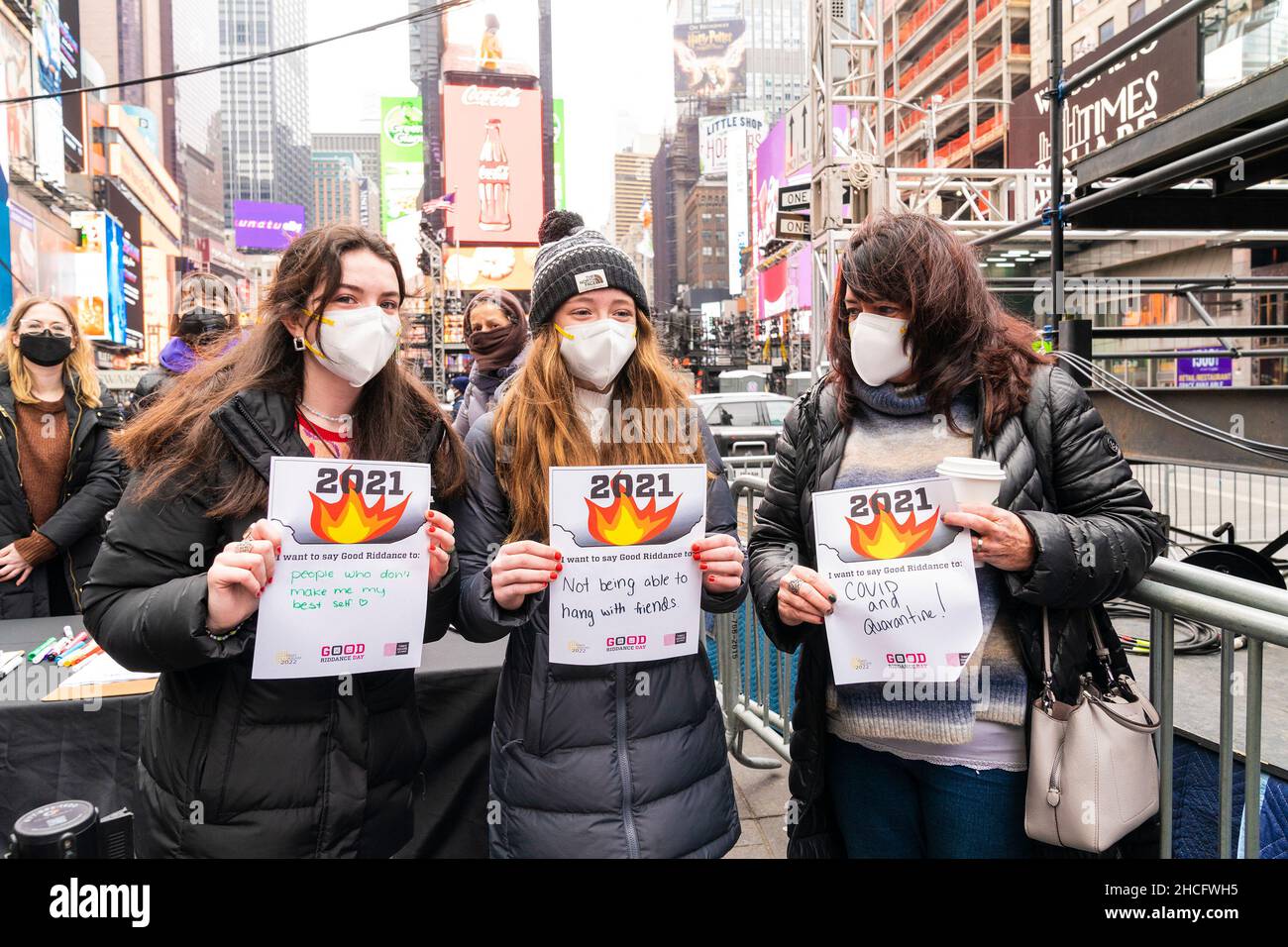 Touristen aus Rhode Island halten mitten auf dem Times Square während des Good Riddance Day in New York am 28. Dezember 2021 in der nach lateinamerikanischer Tradition eingestellten Verbrennungsanlage Papiere mit einer Nachricht bereit, um sie zu verbrennen. ‘diesem Jahr wurde zum ersten Mal, in Übereinstimmung mit der lateinamerikanischen Tradition, große Puppen voller guter Nachrichten zu verbrennen, ein Brenner aufgestellt und das Feuer begann, die Botschaften der Menschen von schlechten Erinnerungen an 2021 zu verbrennen. Die meisten Botschaften standen im Zusammenhang mit der COVID-19-Pandemie, die die Menschen loswerden wollten. (Foto von Lev Radin/Sipa USA) Stockfoto