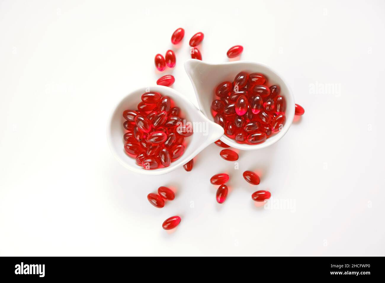 Krillöl rote Gelatine Kapseln in weißen Tassen Set .Omega-Fettsäuren.gesunde Ernährung und Nahrungsergänzungsmittel Stockfoto