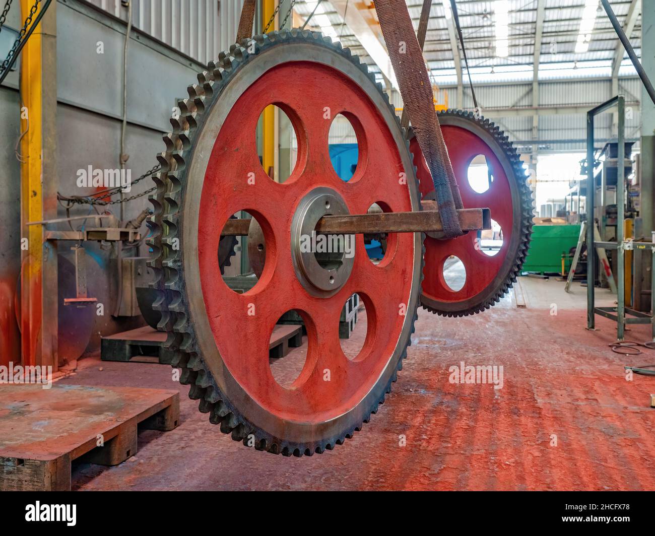 Zwei große Doppelzahnräder in Menschengröße in der Lackiererei einer Fabrik Stockfoto