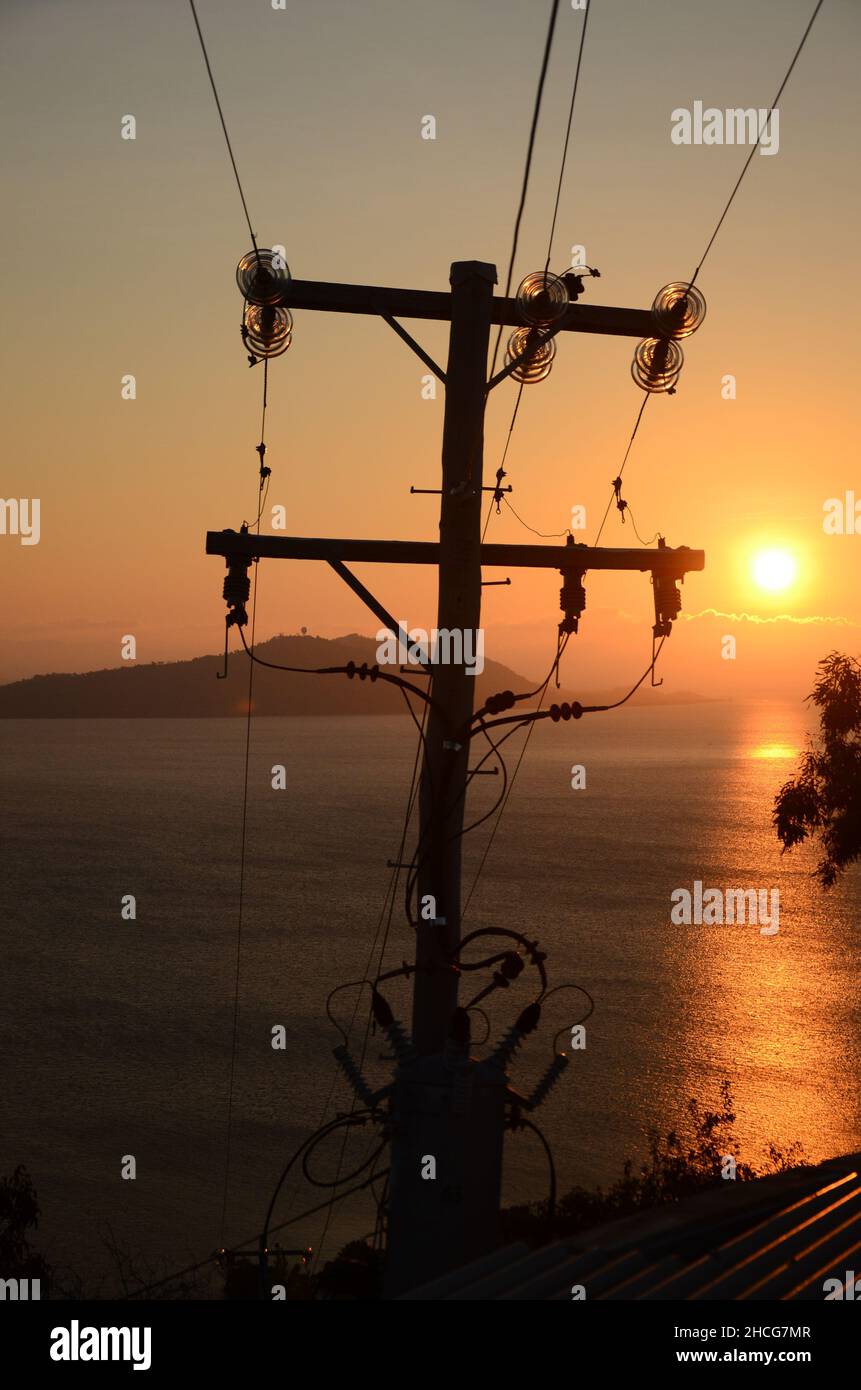 elektrische Hochspannungsleitungen bei Sonnenuntergang Stockfoto