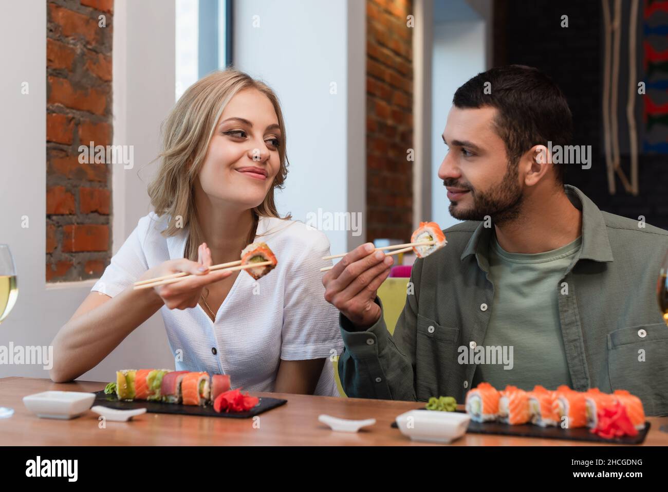 Ein zufriedenes Paar, das sich ansah, während es im Restaurant leckeres Sushi aß Stockfoto